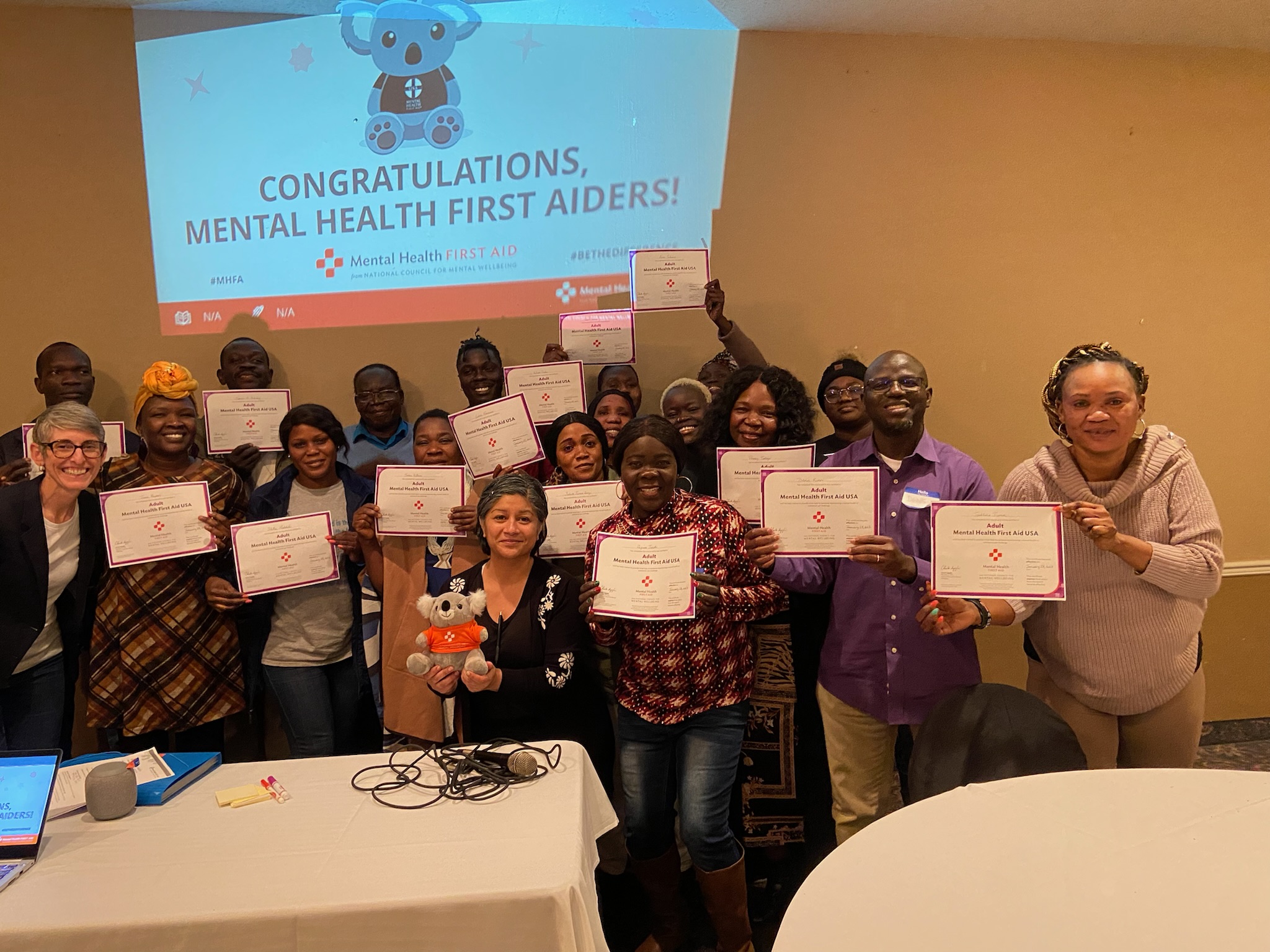 Group holding Mental Health First Aid certificates after completing training