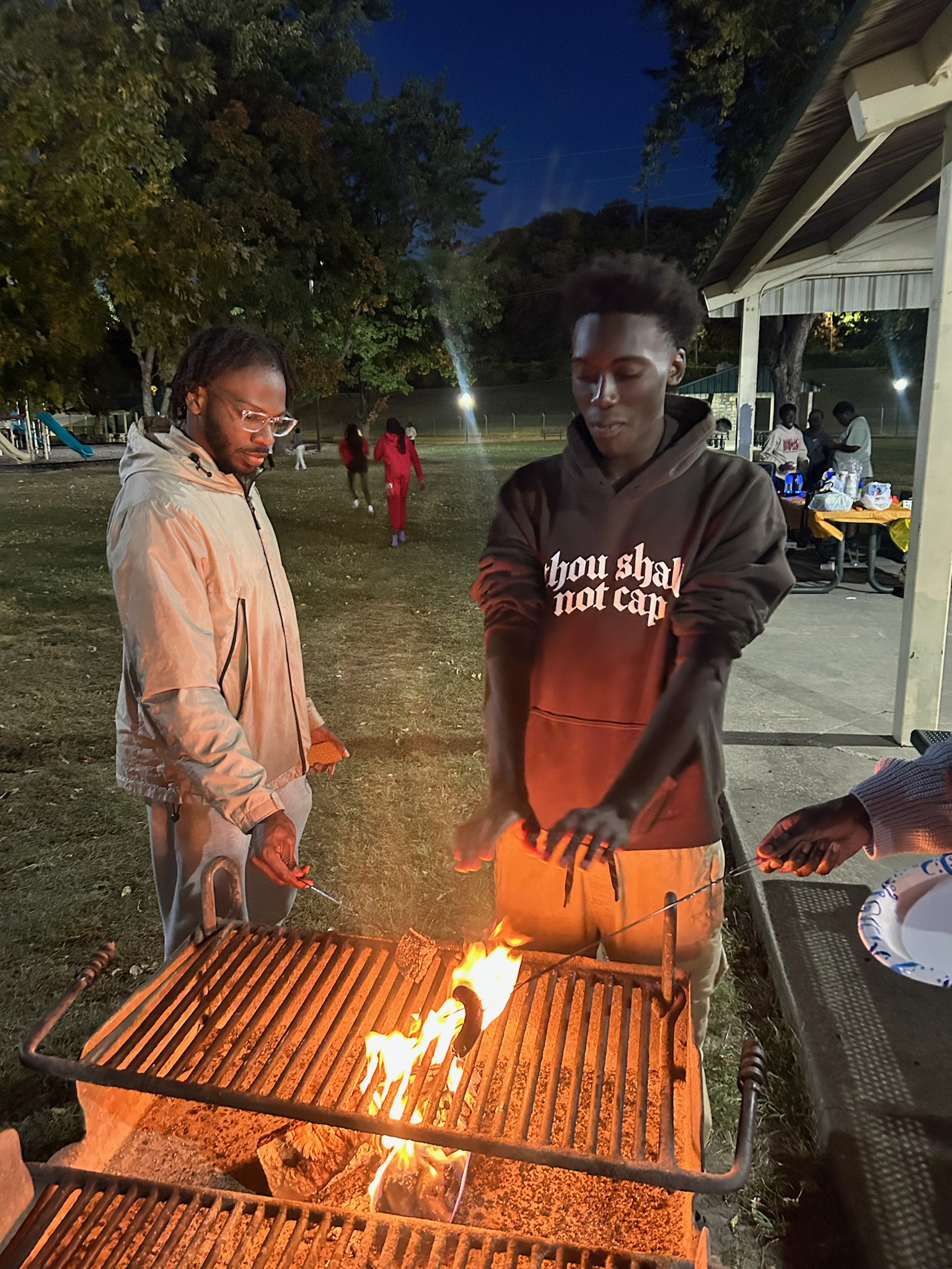 Two people roasting marshmallows over a fire