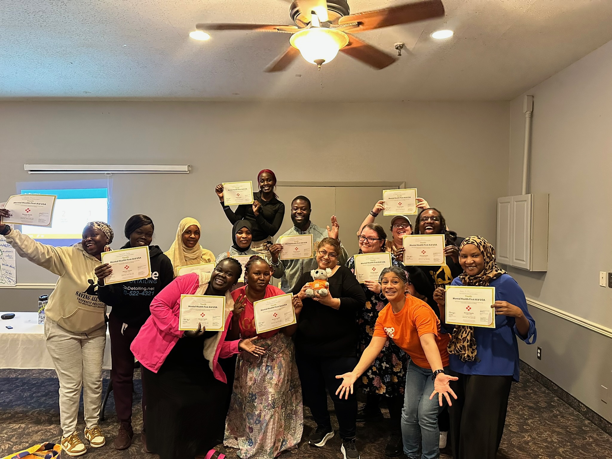 Group holding Mental Health First Aid certificates at the end of training