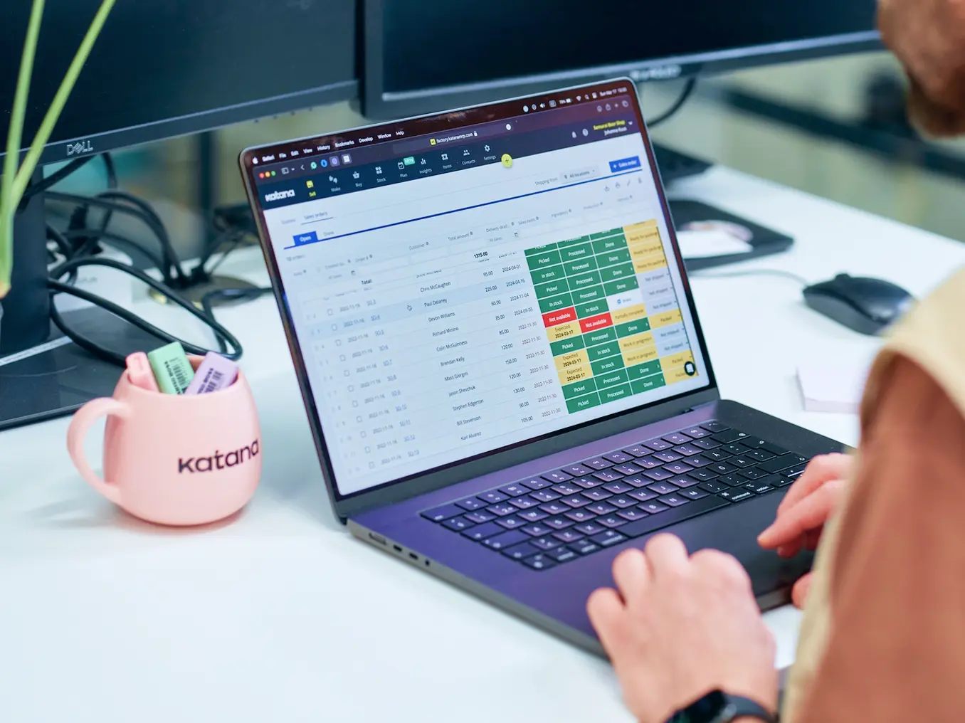 Person working on a laptop dashboard beside a pink Katana-branded mug, Katana case study cover