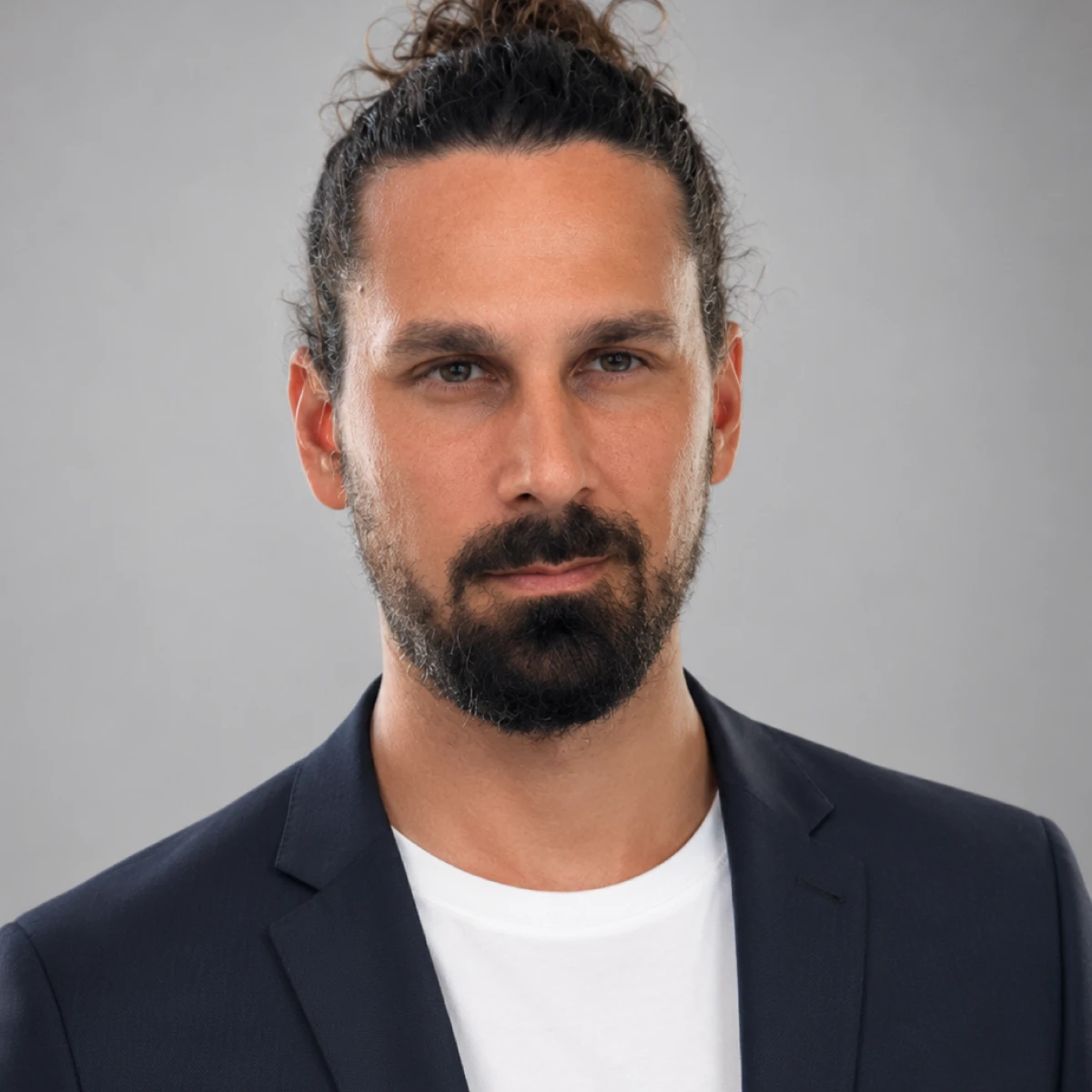 Headshot of bearded man in a navy suit and light blue shirt, T.A. Monroe team