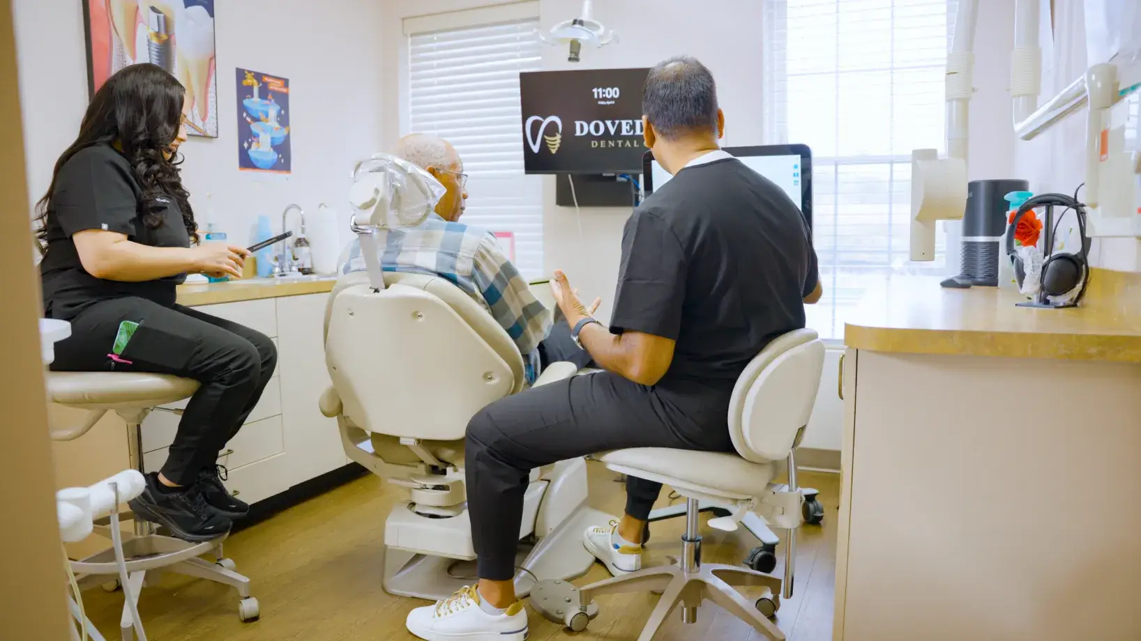 Two people wearing blue gloves touch fingers in the shape of a heart, viewed from below.