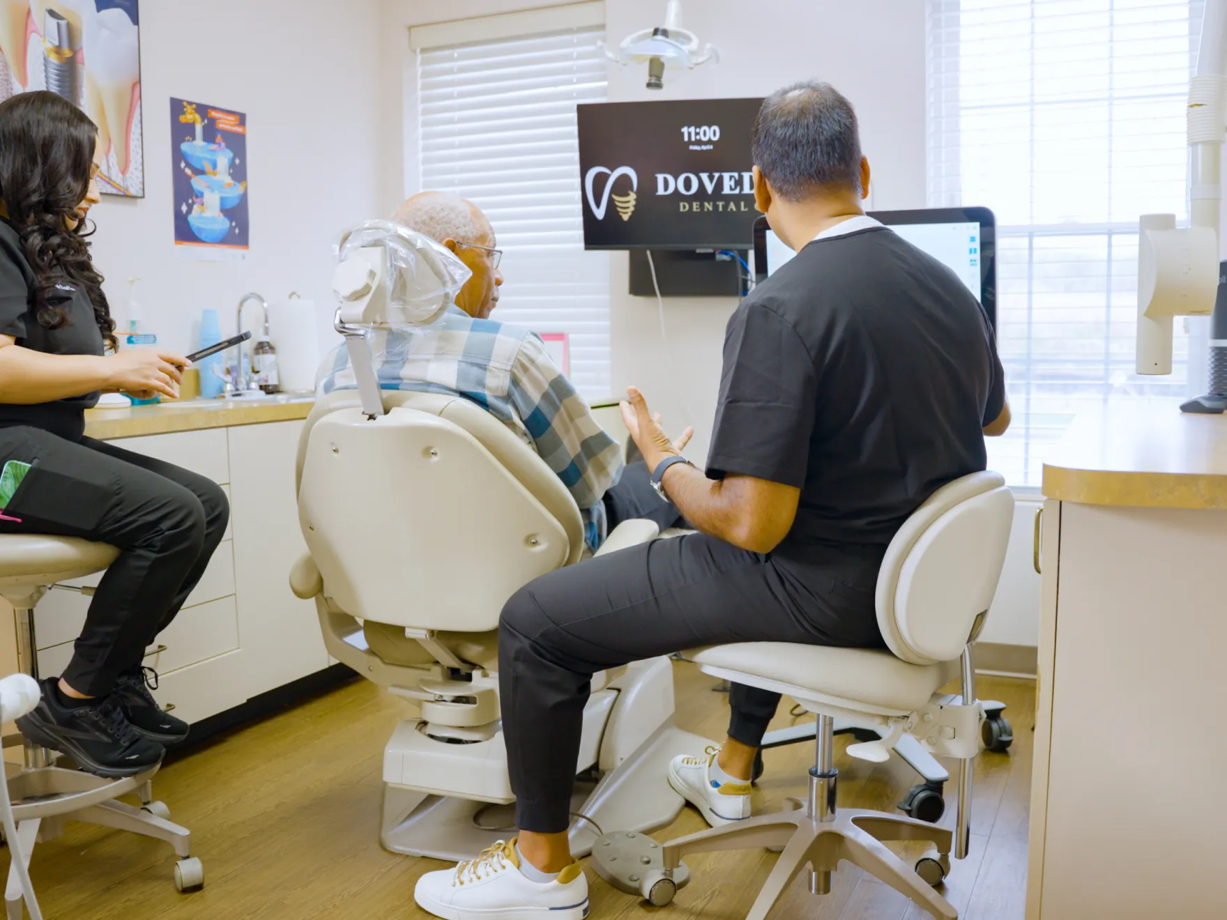 Two women smiling and holding a dental award in front of a sign that says "Dovetail Dental Care."