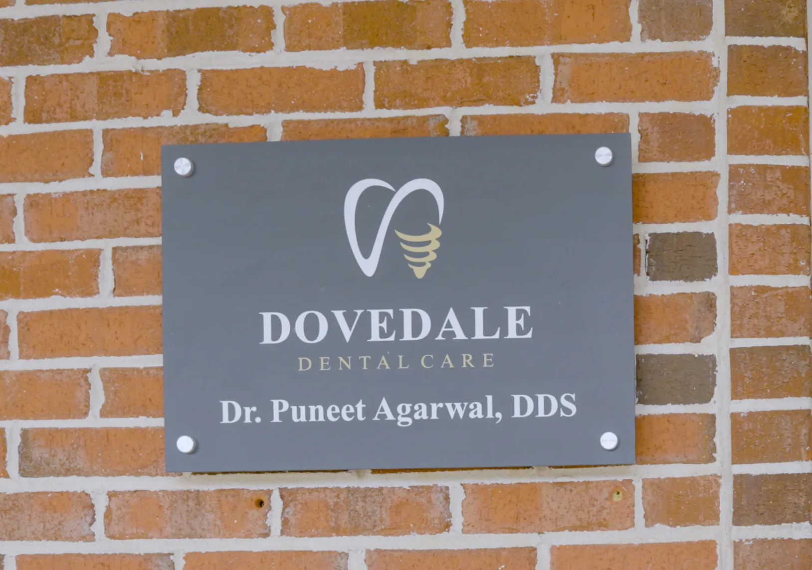 Sign on brick wall reads: "Dovedale Dental Care, Dr. Puneet Agarwal, DDS."
