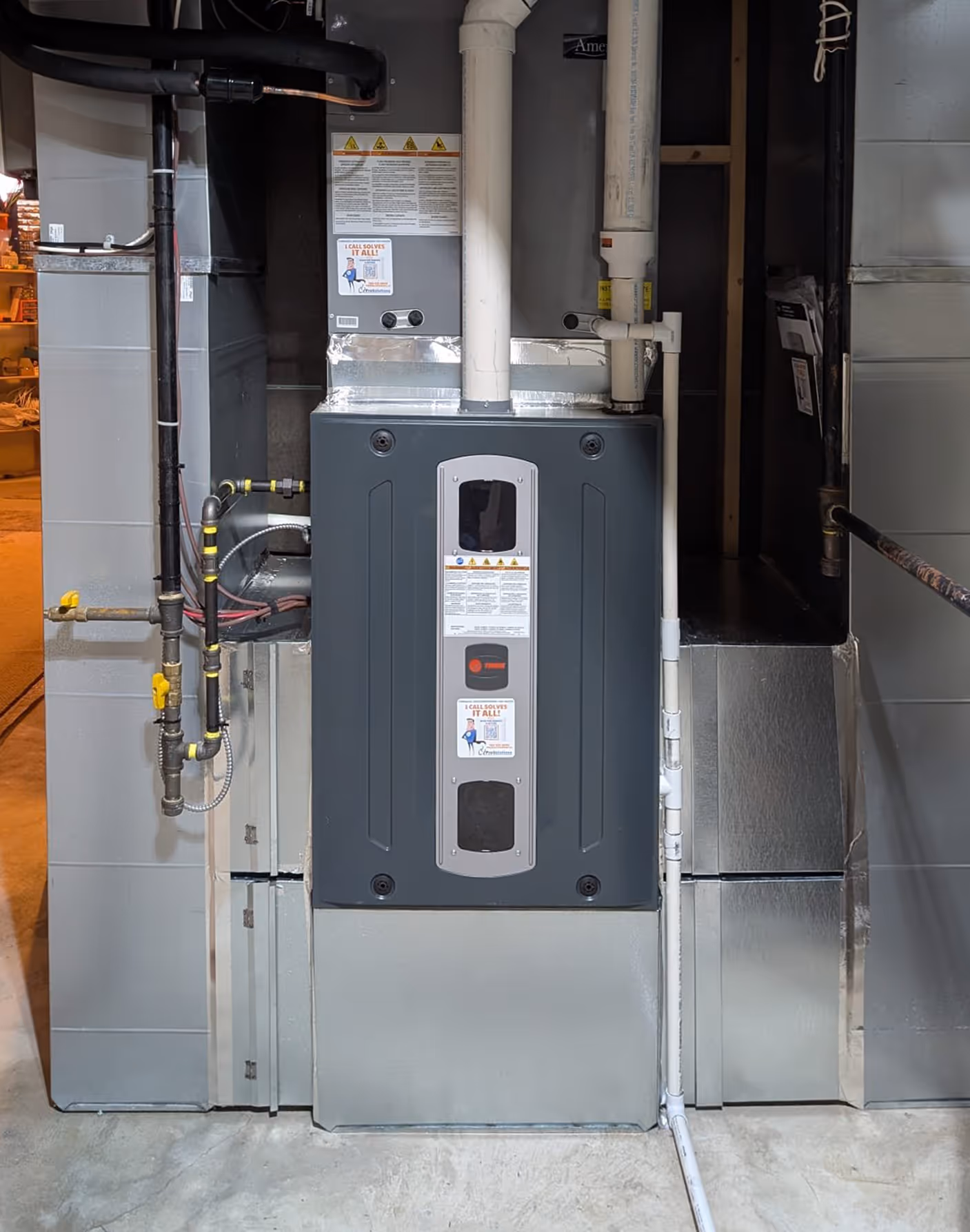 Modern home furnace unit installed in a basement with connected pipes and ventilation ducts.