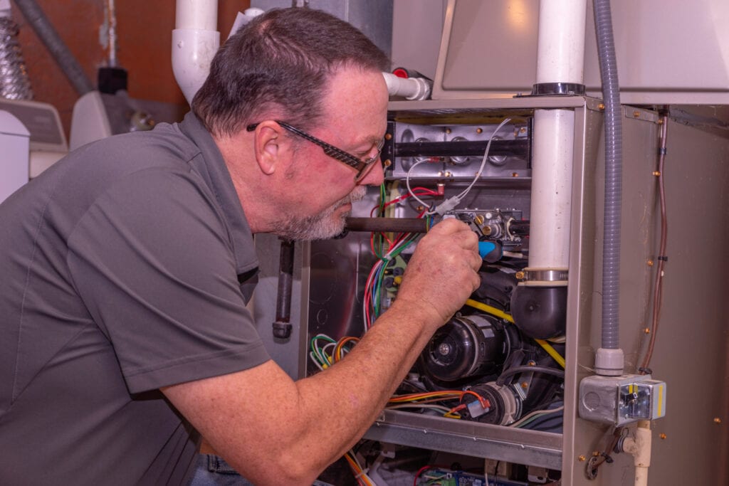 HVAC technician from ProSolutions Heating fixing furnace in Edmonton