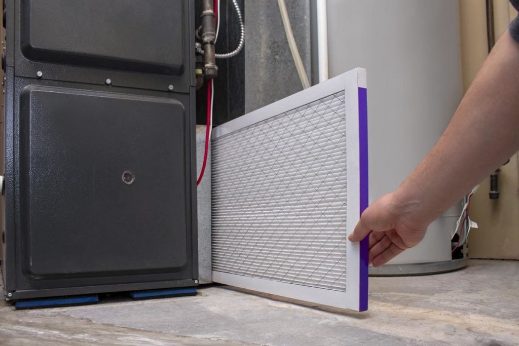 Alberta homeowner checking furnace filter