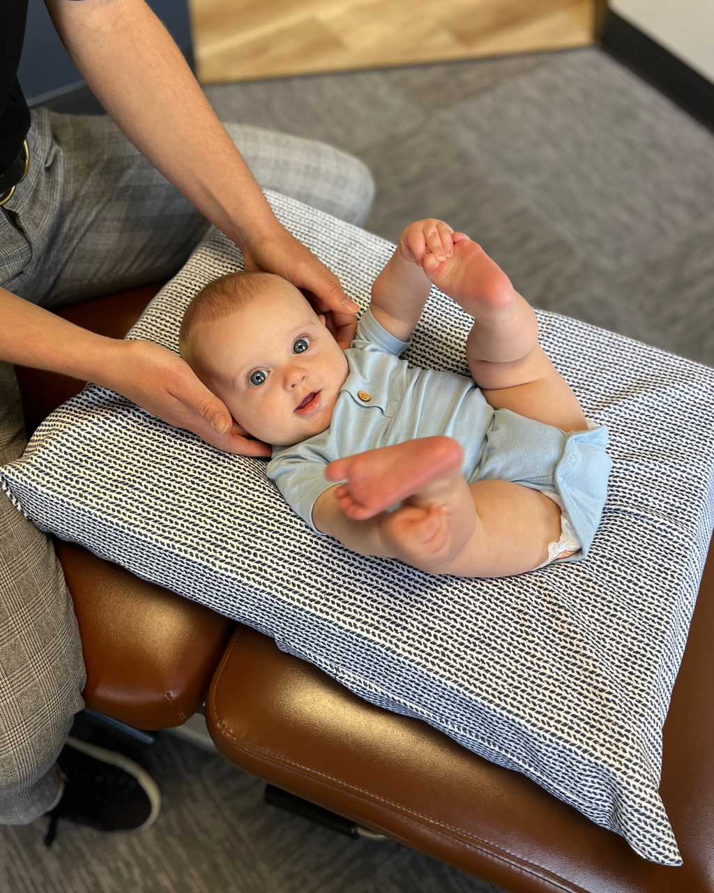 Little baby on chiropractic table with chiropractor 