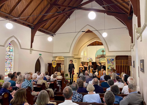 Performers standing to audience in church.