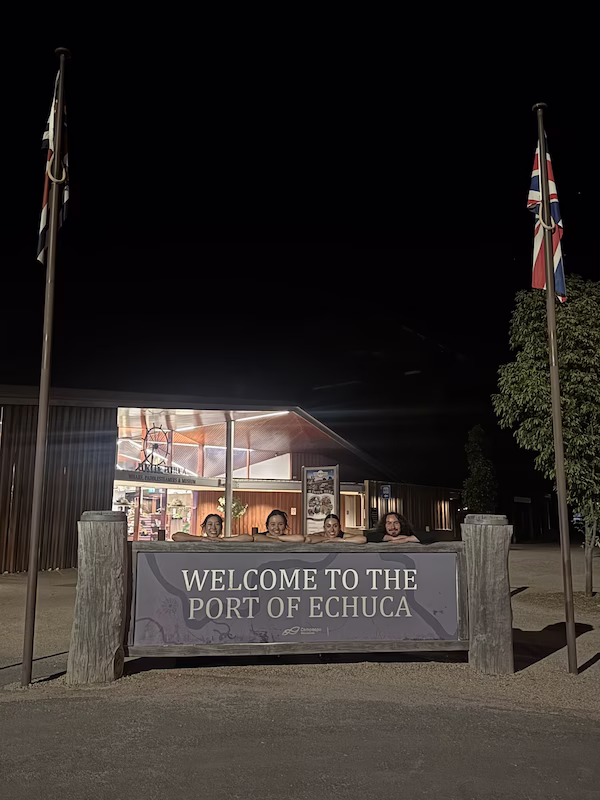 Group of musicians posing on sign that says 'Port of Echuca.'