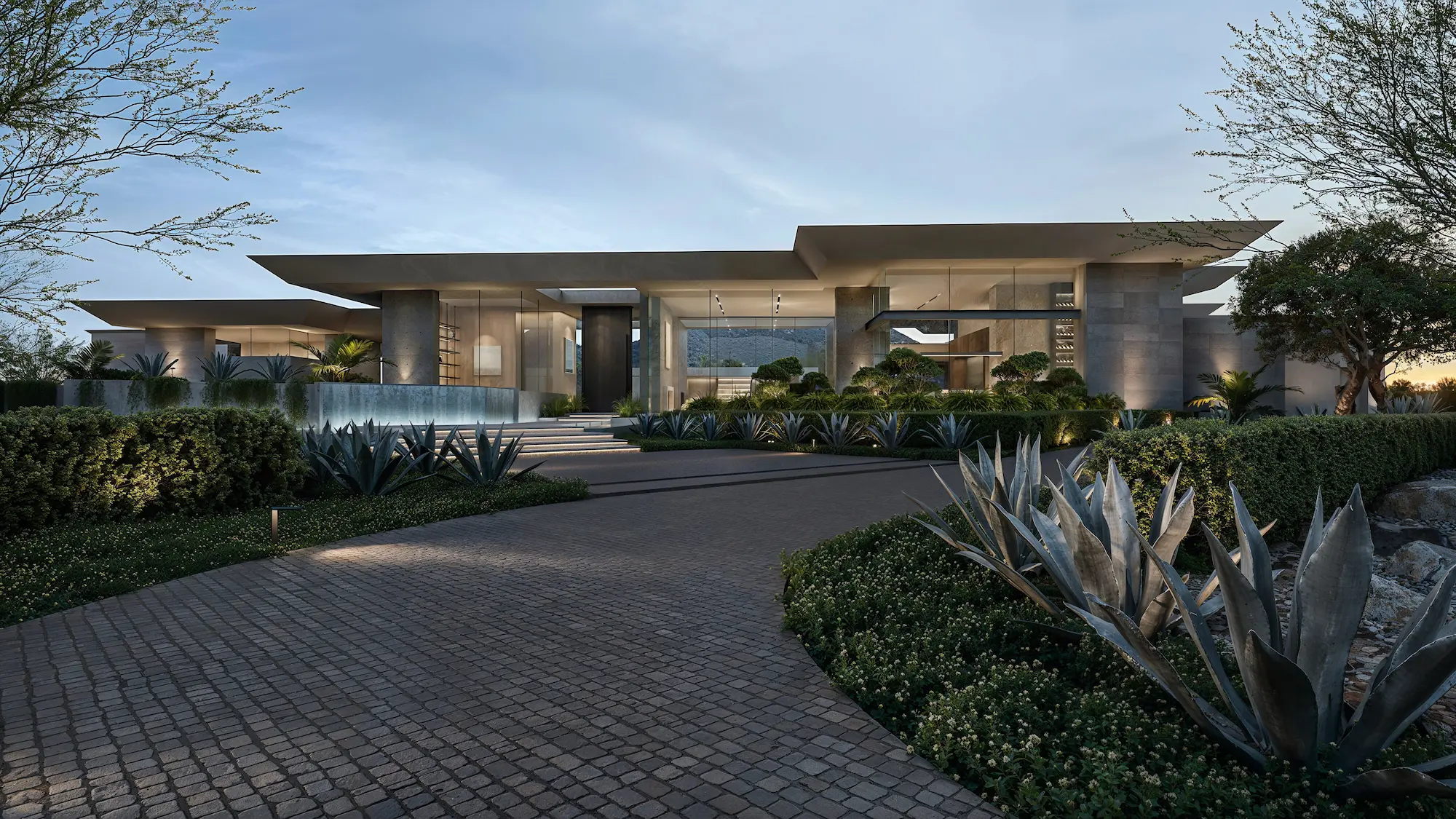 Modern single-story house with large glass windows, surrounded by landscaped garden and agave plants under a twilight sky.