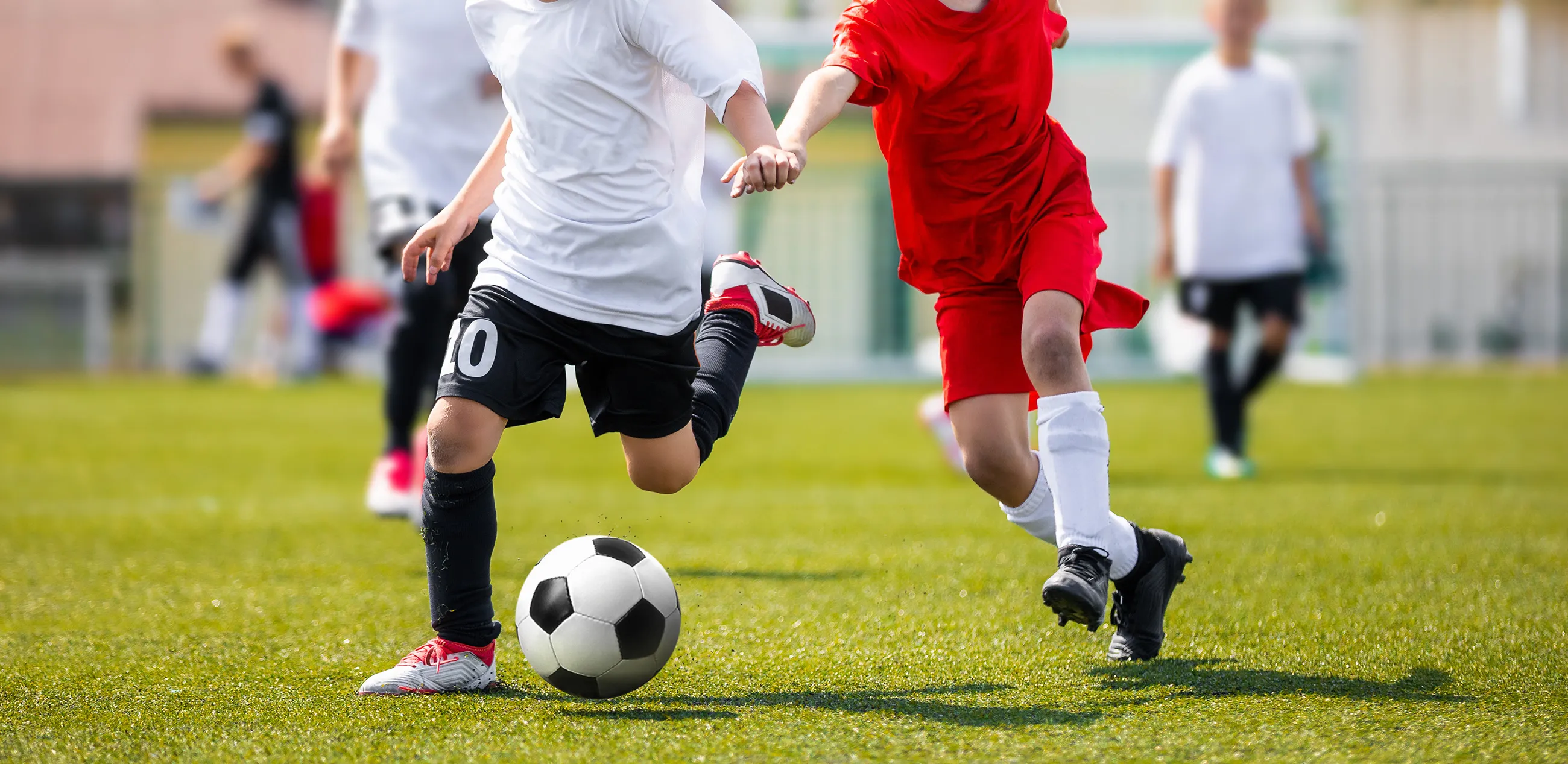 Boys playing soccer on a turf field