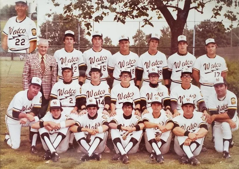 Group photo of a Watco baseball team in uniforms posing outdoors in three rows with a coach in a plaid jacket and an inset image of a player wearing number 22.