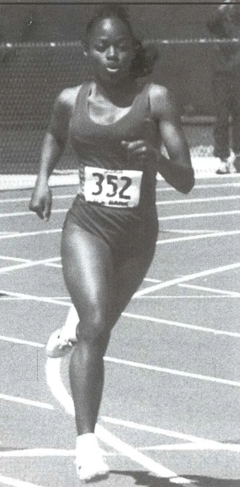 Female track athlete running on a track wearing bib number 352.