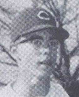 Black and white photo of a young baseball player wearing glasses and a cap with a Cincinnati Reds logo.