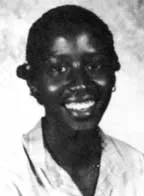 Black and white portrait of a smiling person with short hair wearing a light-colored shirt.