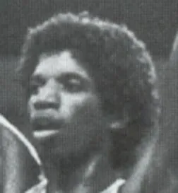 Black and white close-up photo of a young man with curly hair looking slightly to the right.
