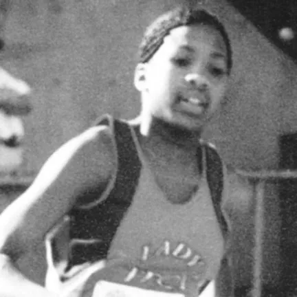 Black and white photo of a young female basketball player wearing a jersey during a game.