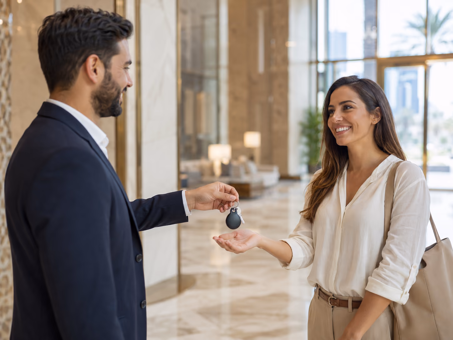 Property manager handing apartment keys to tenant in Dubai residential building lobby