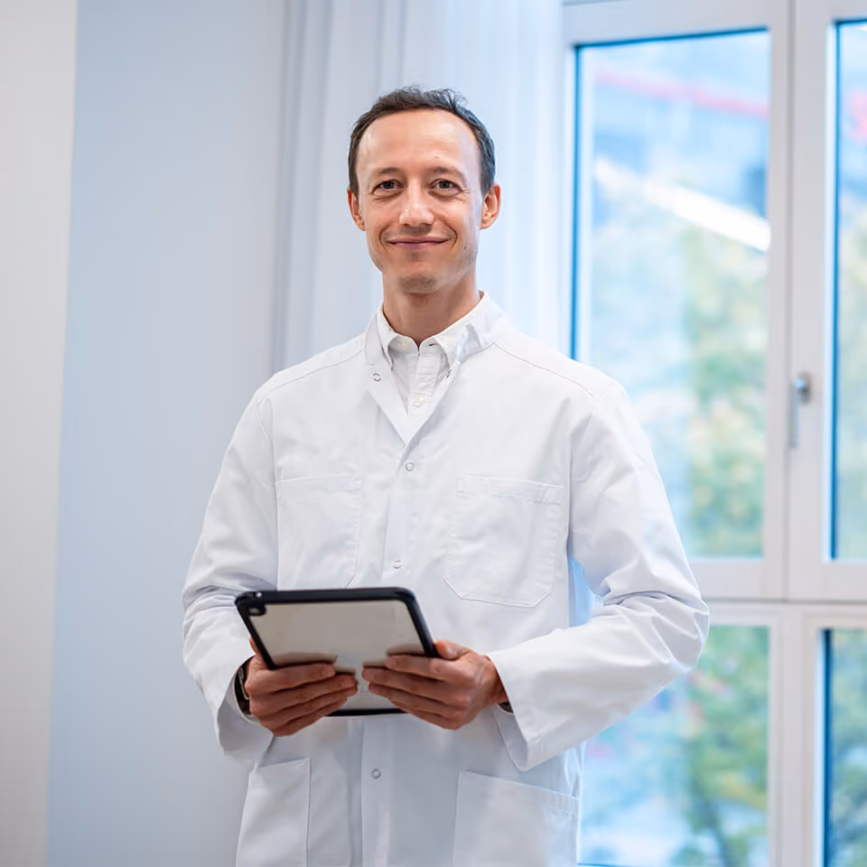 Arzt mit Tablet in einer hellen Praxis