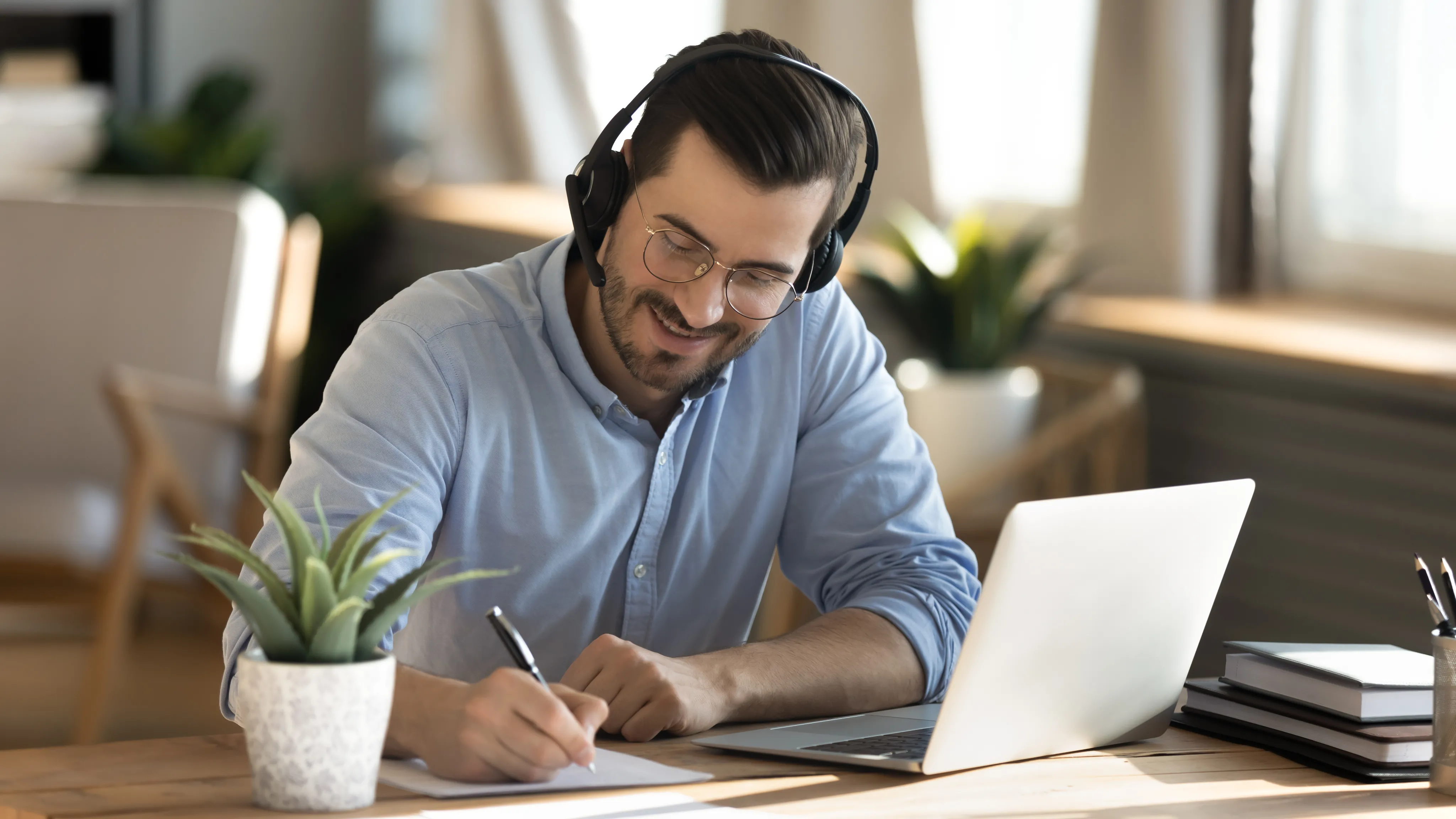 Un homme avec un casque micro qui prend des notes