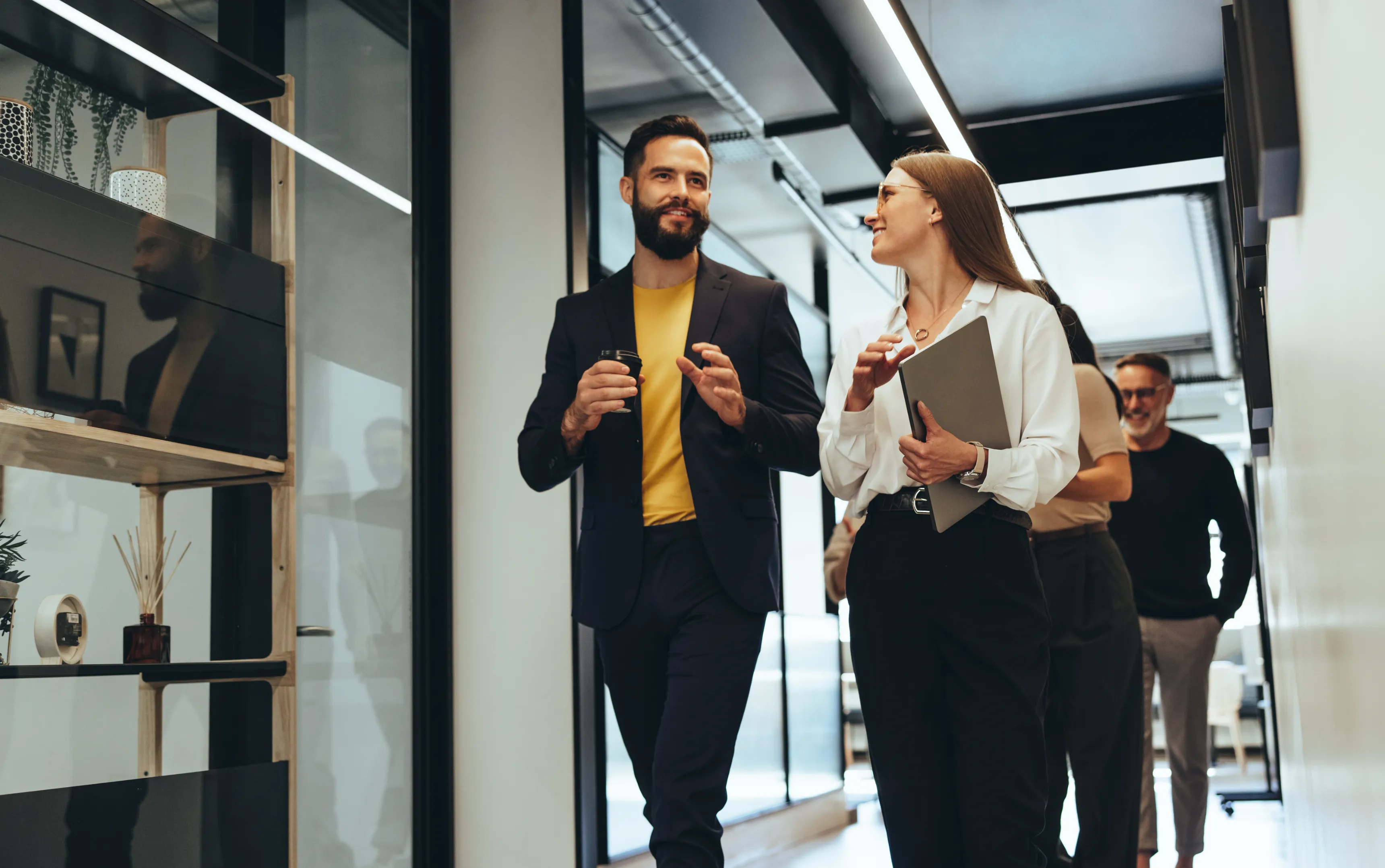 Un homme et une femme discutent debout dans un bureau