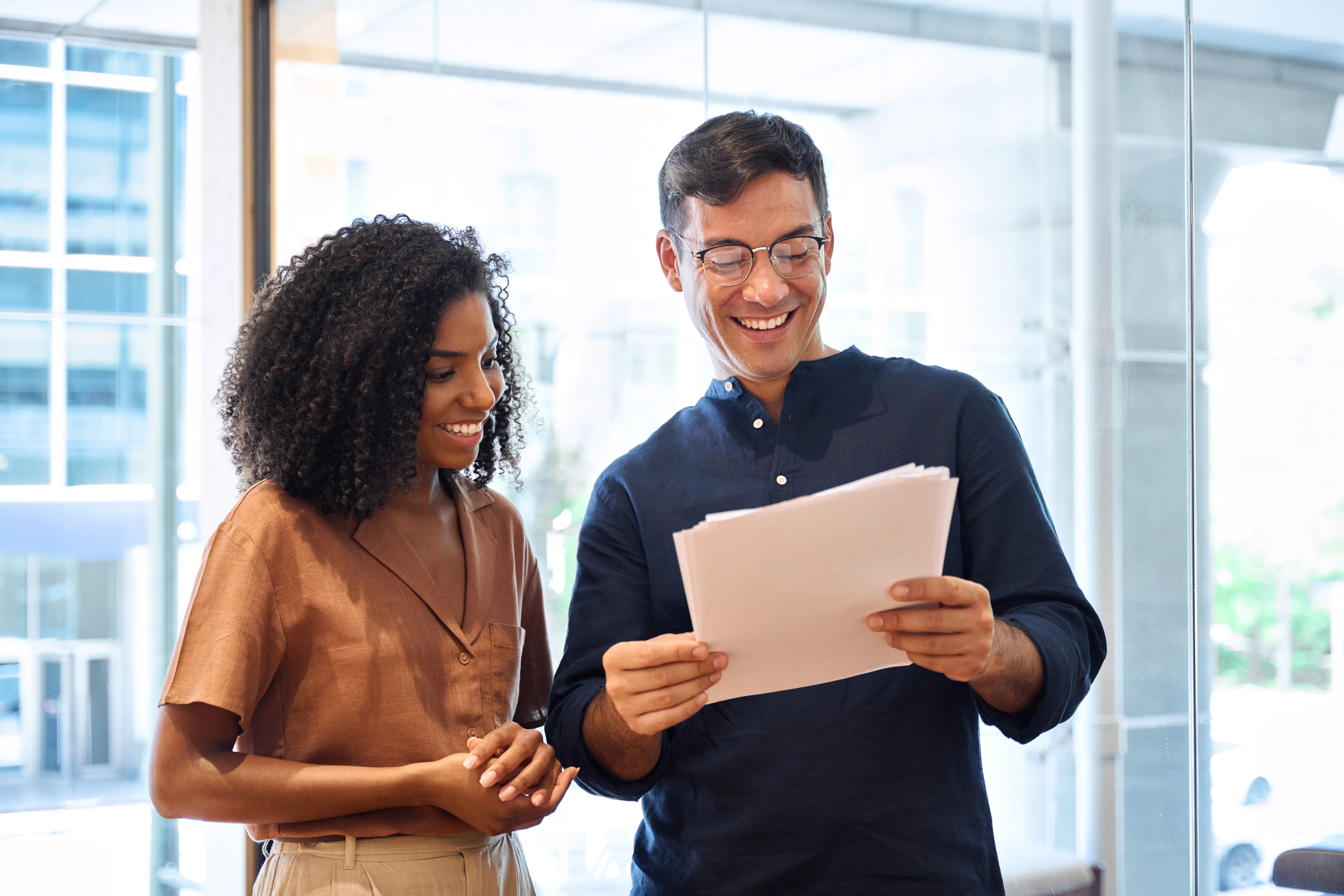 Un homme et une femme debout qui regardent des documents