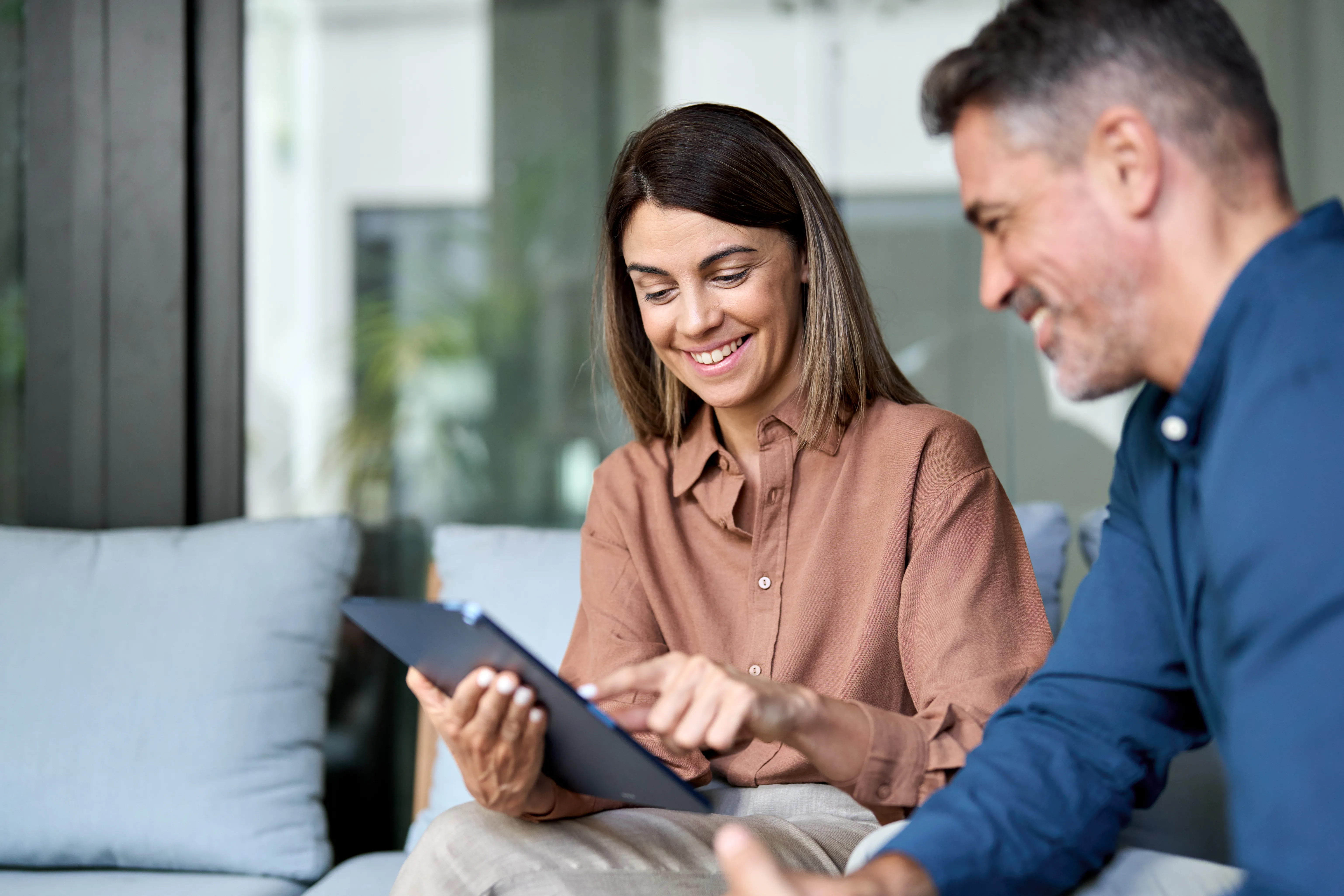 Un homme et une femme souriants devant une tablette
