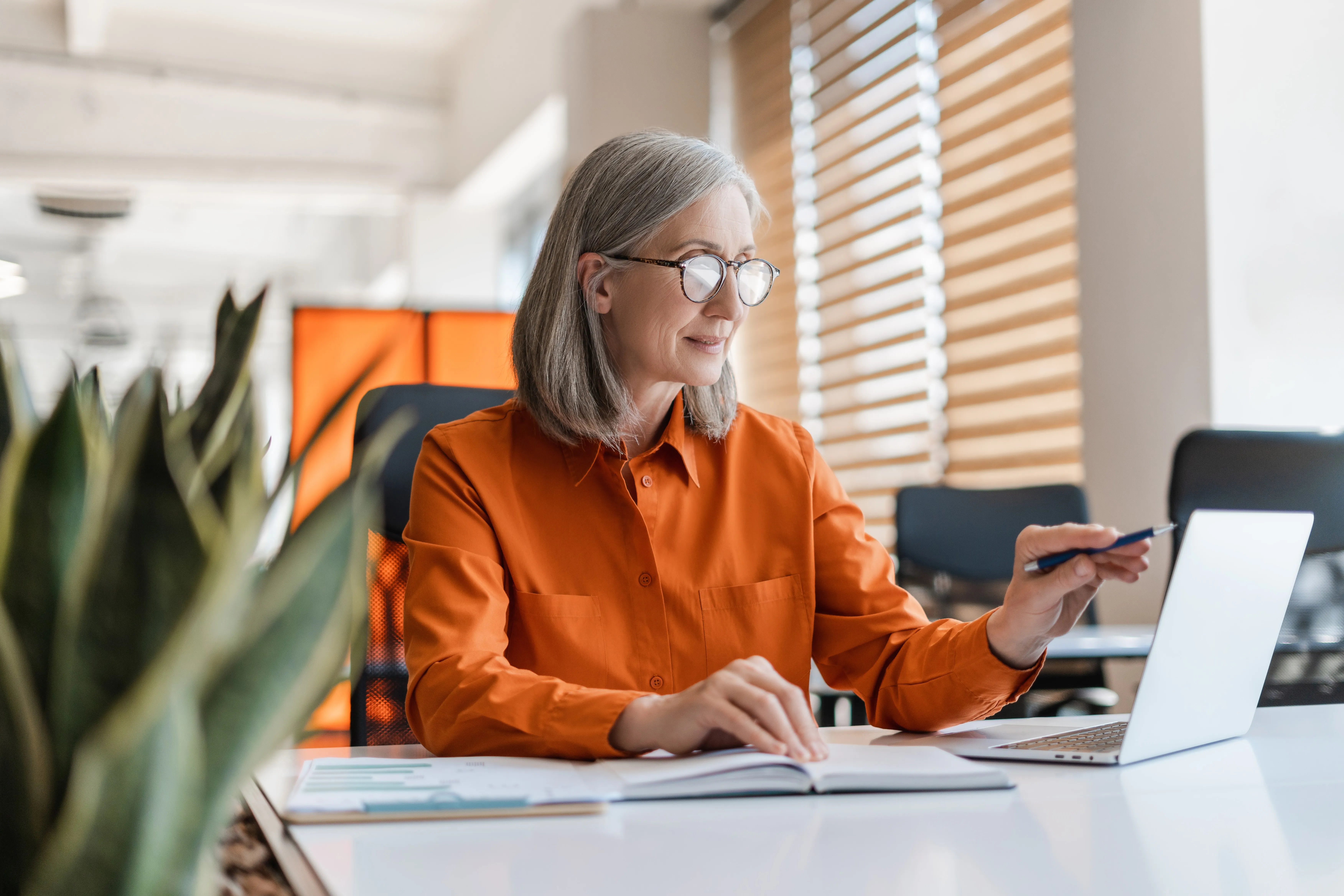 Une femme assise sur un bureau avec un ordinateur