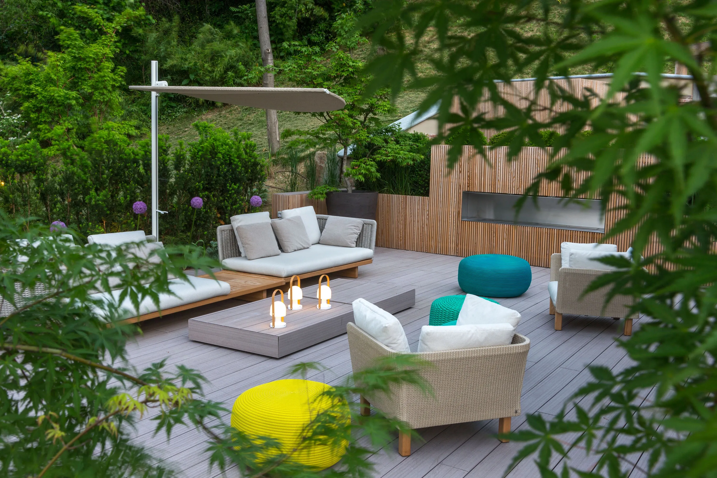 Vista su un patio con sedie coperto da una folta vegetazione
