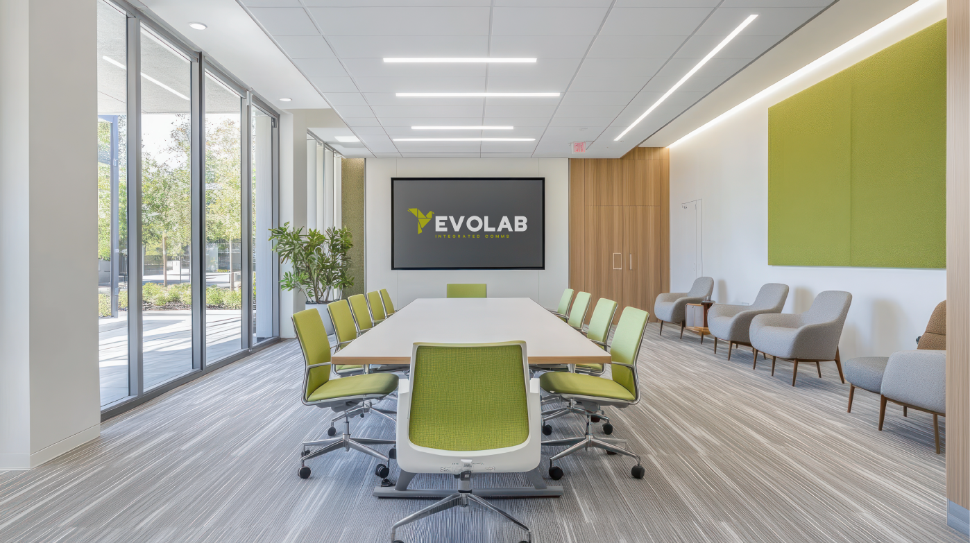A boardroom with green chairs and a TV Screen Showing Evolab Integrated Communications Logo