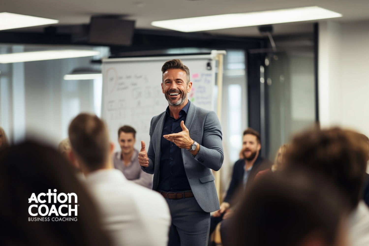 A man in a room full of business people giving a presentation