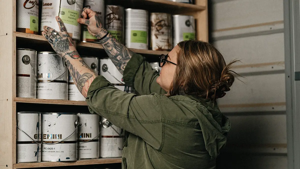 Lyndsie selecting a paint can from a shelf
