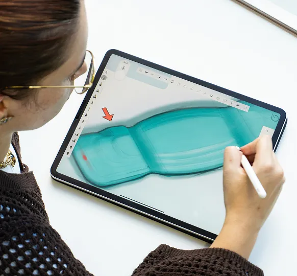 Pessoa a desenhar digitalmente o design de um sapato numa tablet com uma caneta stylus.