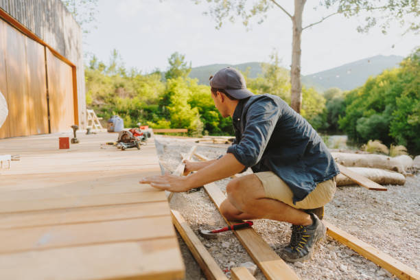 DIY homeowner measuring wooden beams to build a sturdy patio cover frame