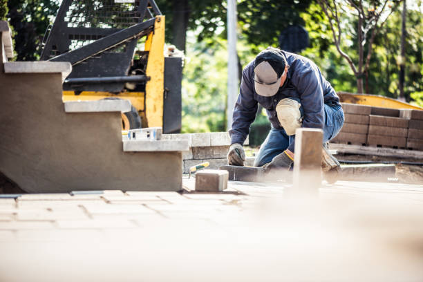 Worker installing support beams to shore up a raised stone patio above grade