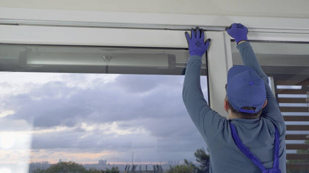 Close-up of hands adjusting sliding patio screen door rollers during installation