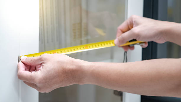 Close-up of a person measuring the width of a sliding patio door before purchase