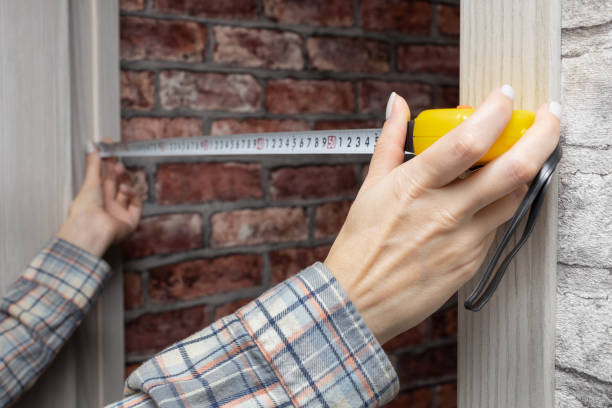 Measuring tape extended across a patio door frame to determine standard patio door width