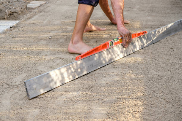 DIY homeowner leveling ground in preparation for brick patio construction