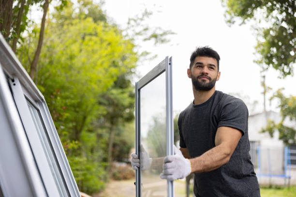Person wearing gloves handling glass panel during sliding patio door removal
