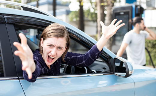 angry woman leaning out of car to yell 