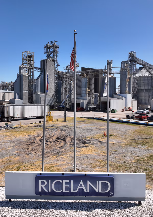 Riceland facility with flags and industrial structures.