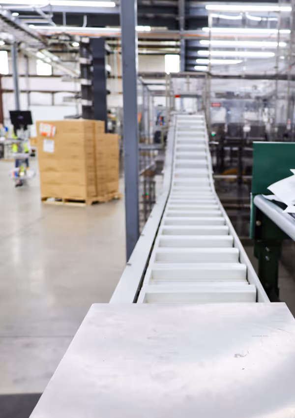 Conveyor belt inside a brightly lit Riceland processing facility.