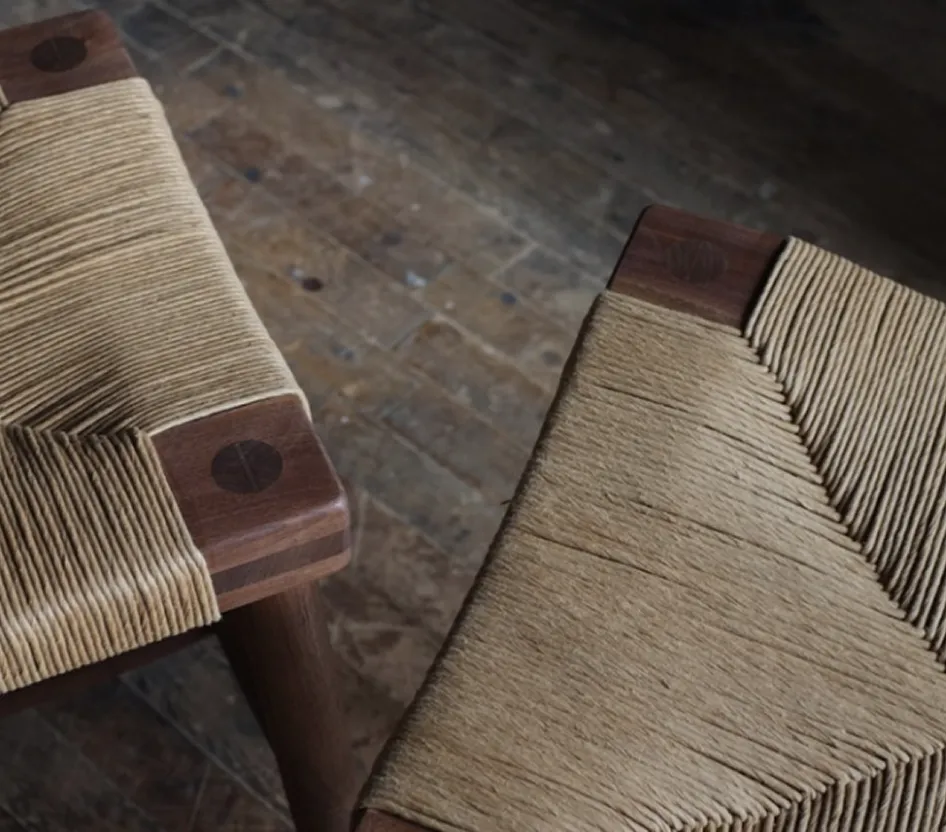 A close up of a chair with a wooden seat.