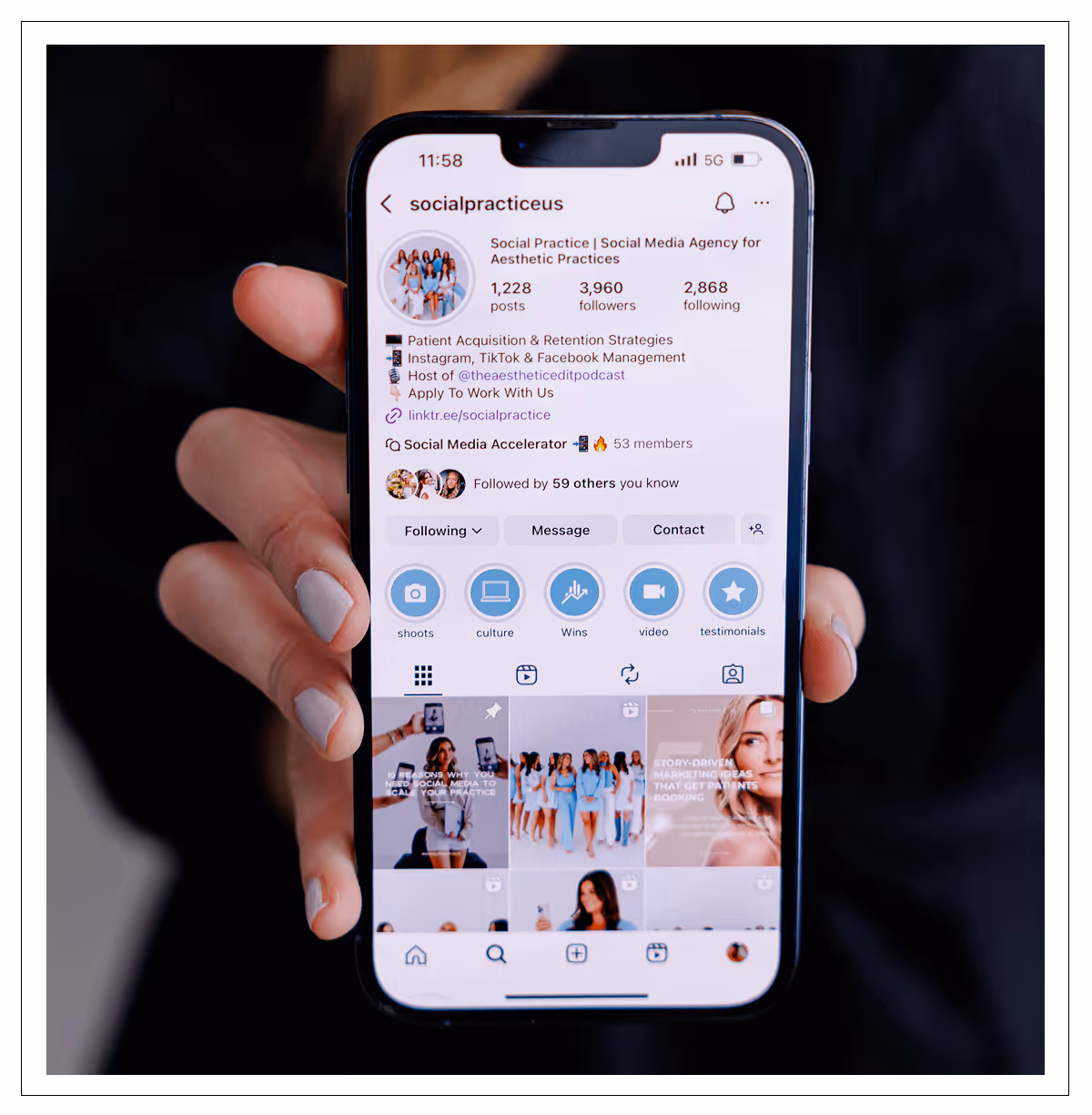 Hand holding smartphone displaying Instagram profile of Social Practice, a social media agency for aesthetic practices.