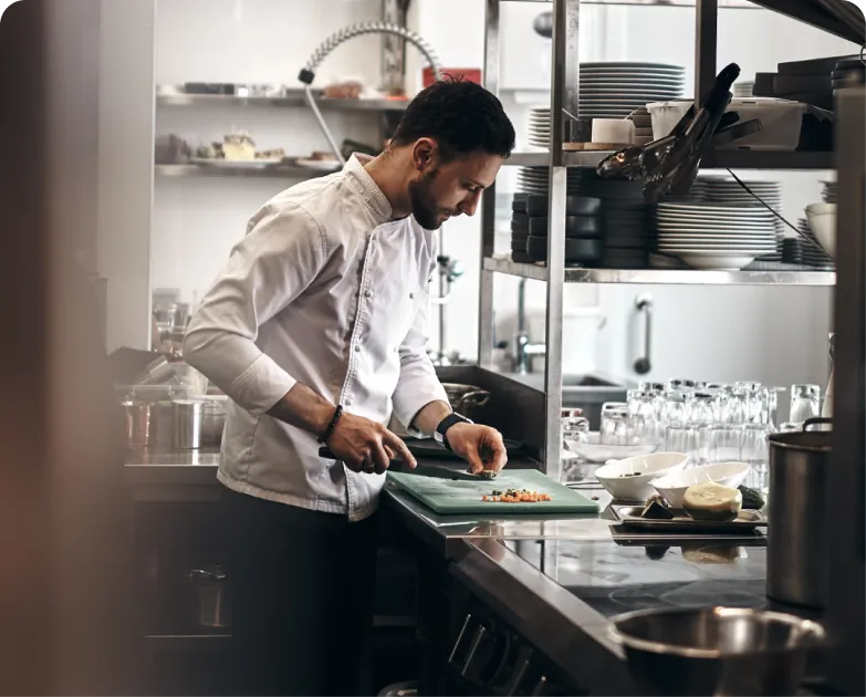 A chef mincing vegetables in a clean and organized kitchen