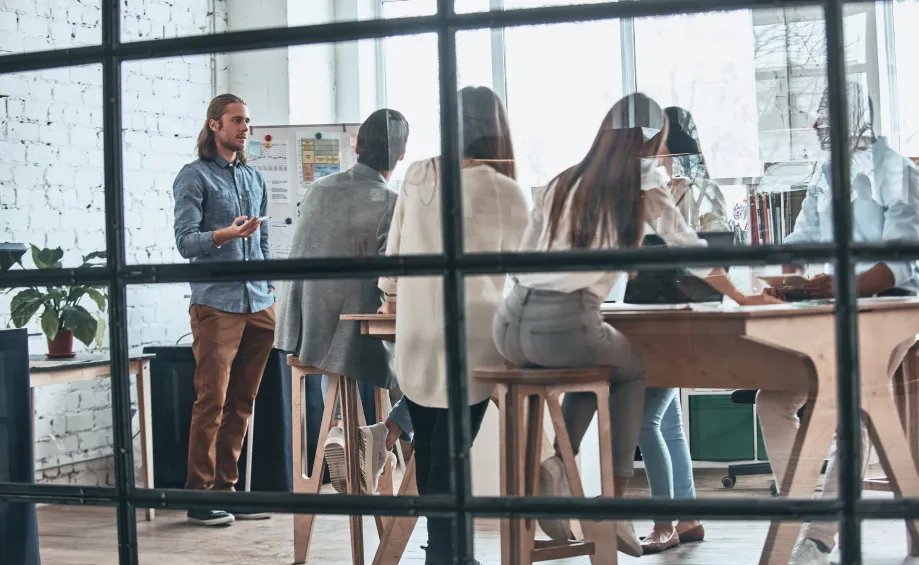 a group of people standing around a wooden table