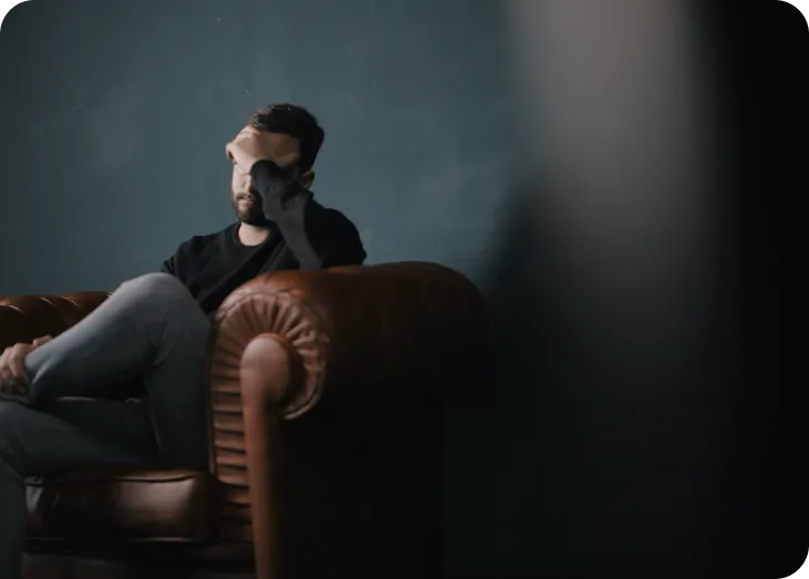 a man sitting on top of a brown leather chair