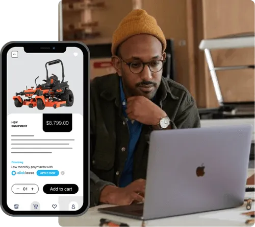 A man in a beanie looking at a computer with a new equipment quote phone beside him